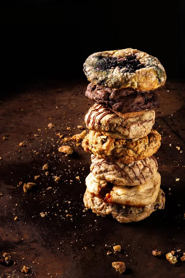Fresh baked cookies and pastries styled on a dark surface